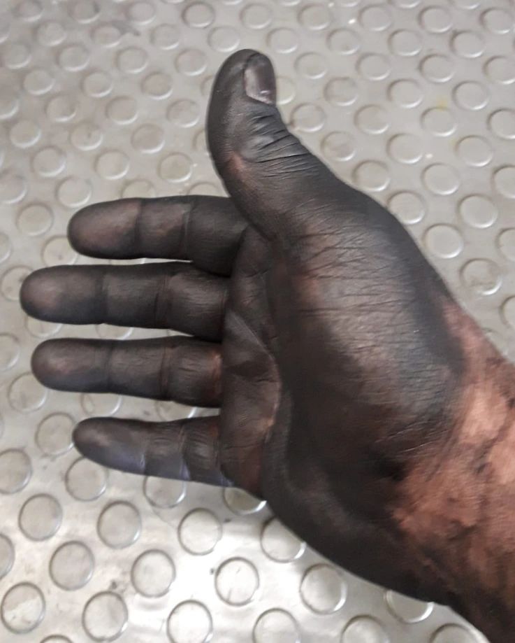 Eine ölverschmierte Hand nach der Arbeit am Motor