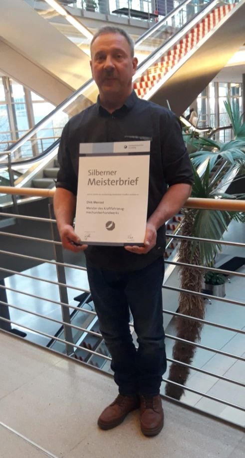 Dirk Menzel hält seinen Silbernen Meisterbrief der Handwerkskammer zu Leipzig